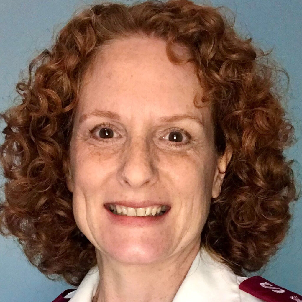 Freckled white woman with curly red hair smiling